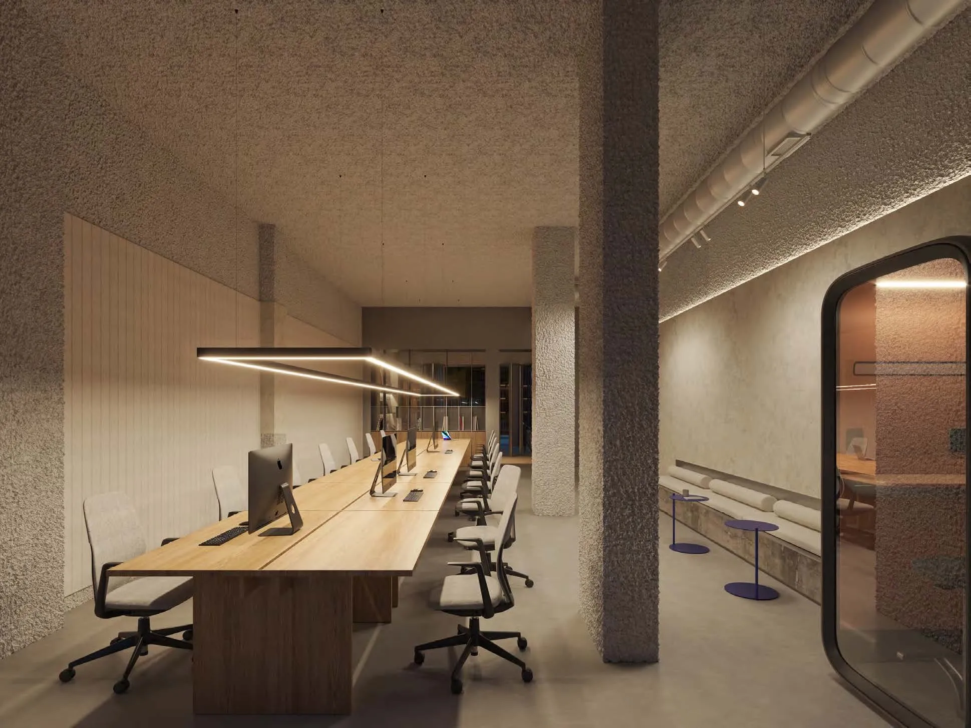 Visualización de la zona de coworking con mesas largas y puestos de trabajo