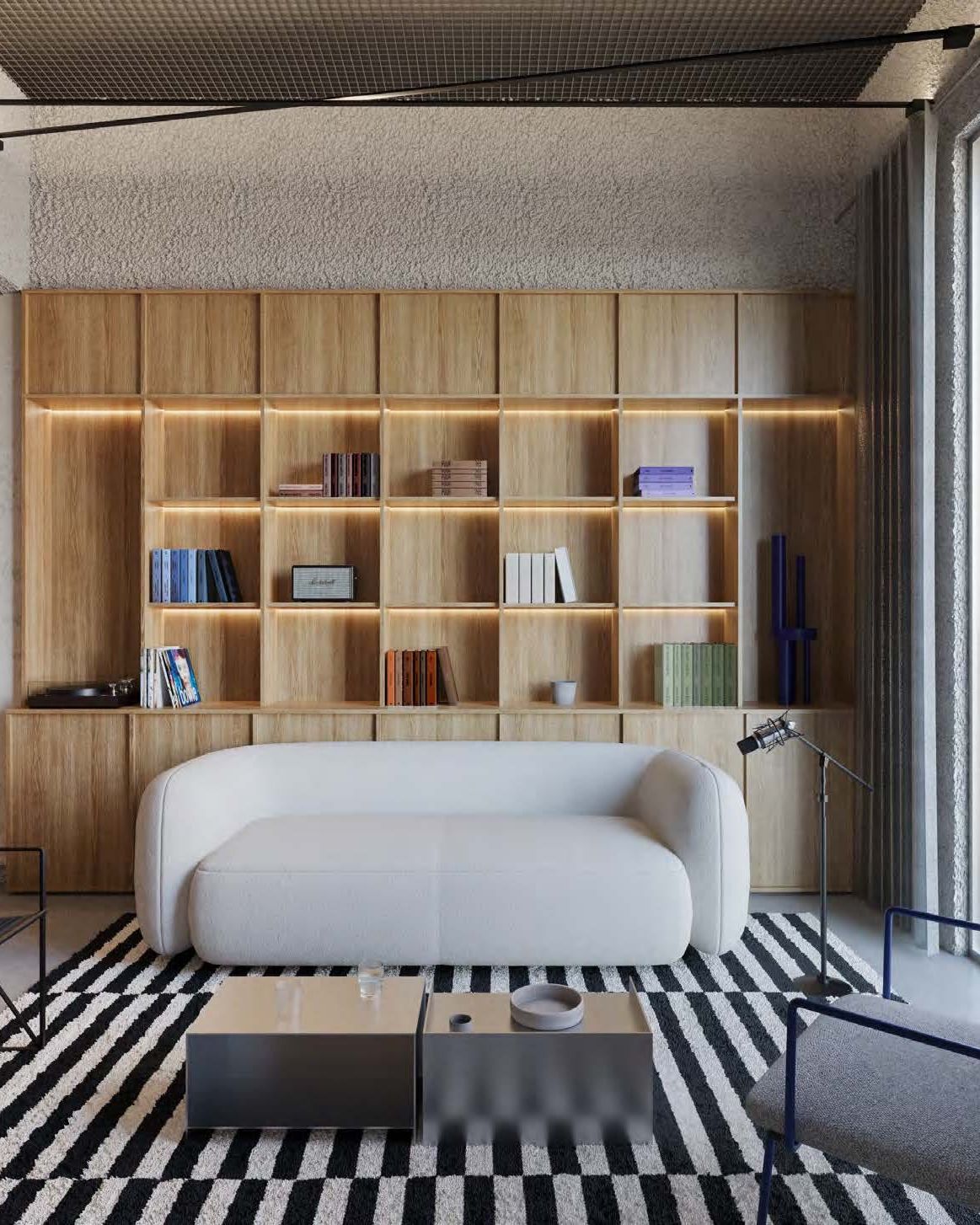 Visualización de la zona lounge con estanterías de libros y vinilos